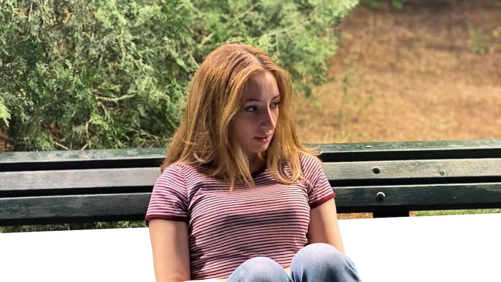 Girl sitting on a bench.